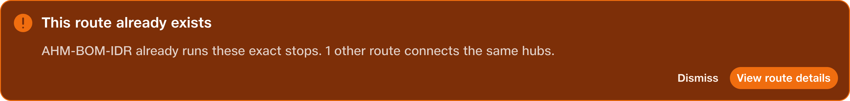 An amber warning says This route already exists, identifies AHM-BOM-IDR and offers View route details and Dismiss.